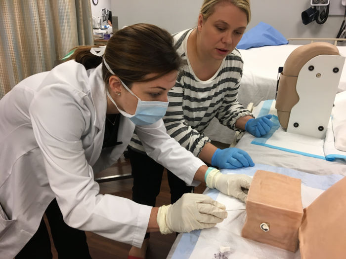 A nursing student practicing on a model.