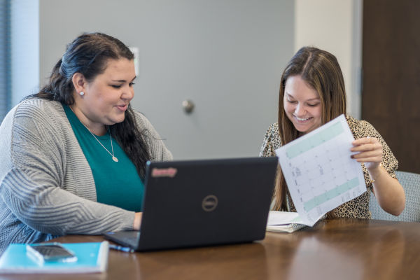 A student and instructor verifying work on a laptop
