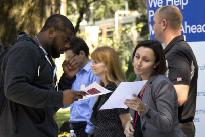 Depiction of a career fair with student and counselor reviewing a printed document.