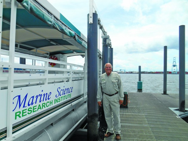 Dr. Quinton white next to the floating classroom boat