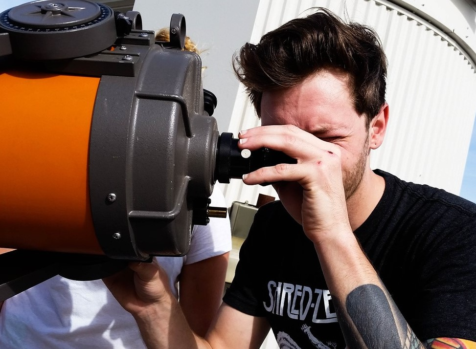 Male students using a telescope.