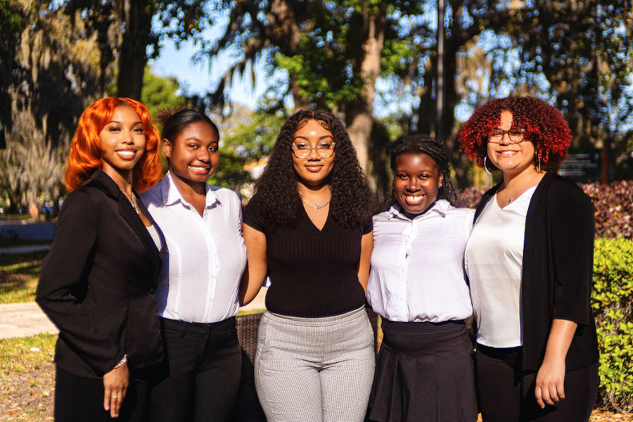 a group of young people posing for a photo with arms enlaced around each other