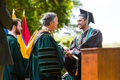 President Cost congratualtes a graduate during commencement