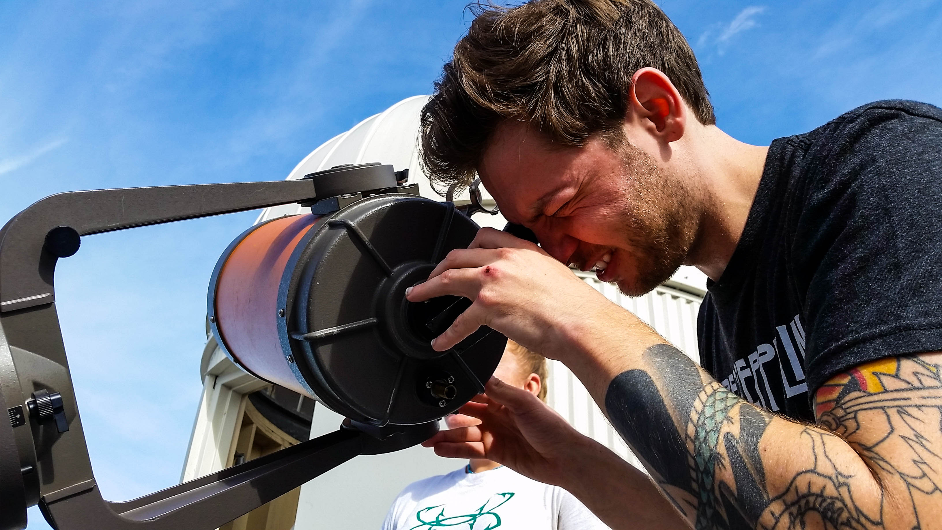 student looking into a telescope