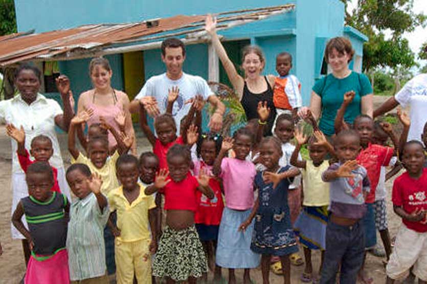 JU students posing with children in Mozambique
