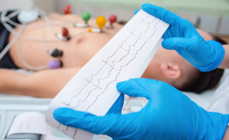 EKG Technician reads out graph with a patient