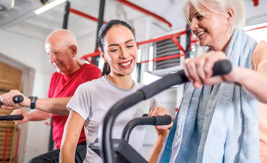 Physical trainer helping elderly patients during a therapy session