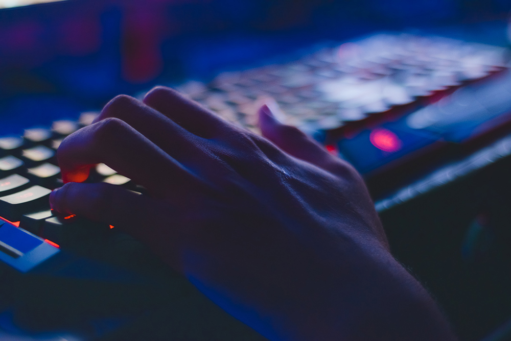 Hands on a lit up keyboard